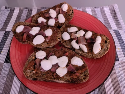 Bruschette with sun-dried tomatoes pesto, prosciutto and mozzarella